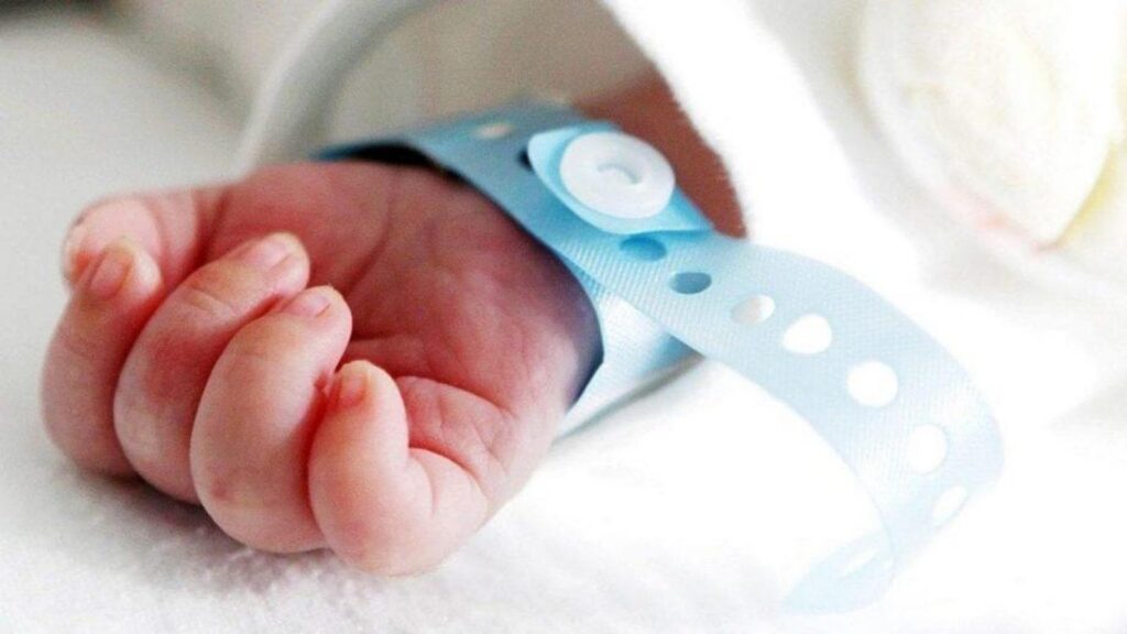 Pulseira de identificação infantil ao redor do braço de um bebê recém-nascido.
